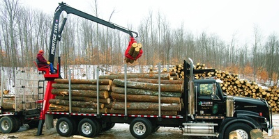 A-Frame Knuckleboom Loader loading logs onto a truck