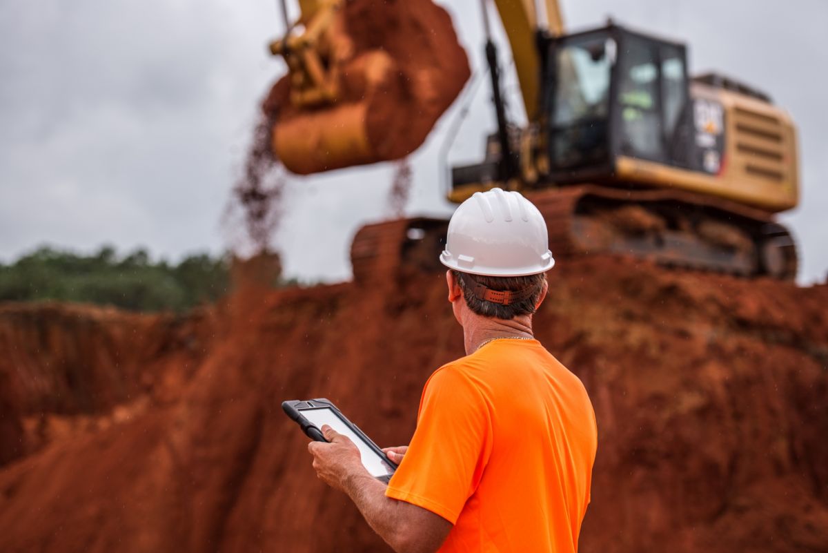 A man wearing safety equipment observing machinery