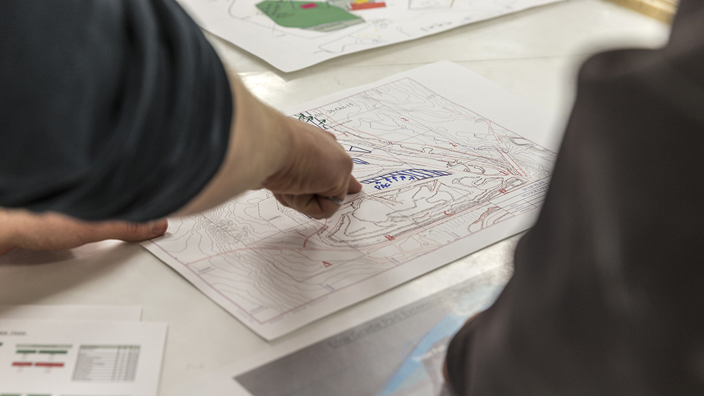 miningsolutions-timeline-2 Workers analyzing a topography map