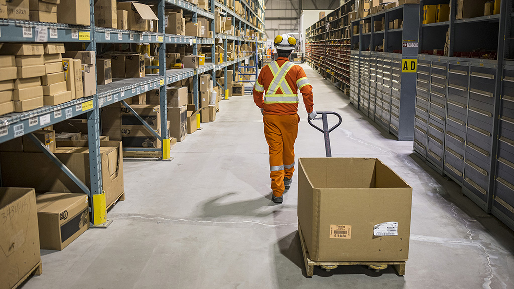 miningsolutions-timeline-5b A worker transporting a box in a warehouse