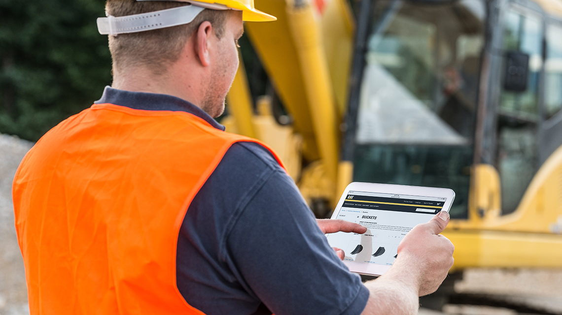 AmN_QuarryAgg_secondary_images_19 Construction worker looking at toromont website on a tablet on construction site