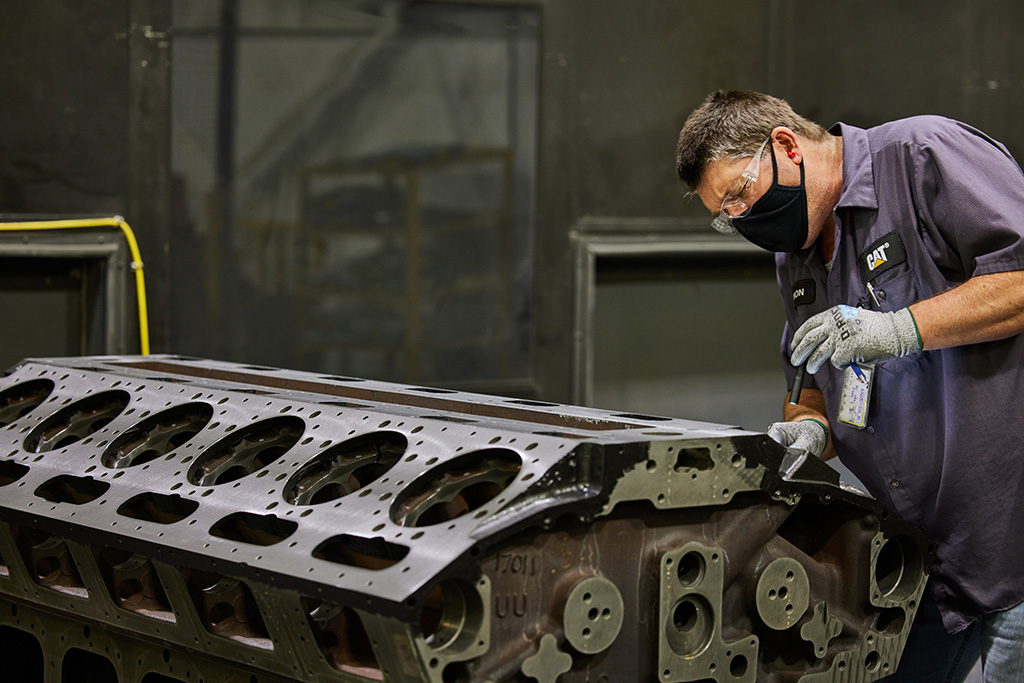 jcn27032-cat-reman-3500-engine-post-spray-detail-simon-attree Worker inspecting construction machinery