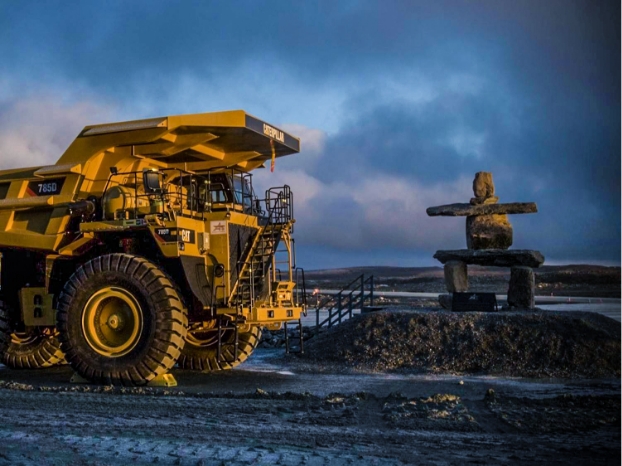 sustainabilitycommunity-community2 A mining truck drives by an Inukshuk