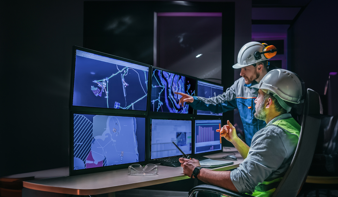 Workers analyzing construction site data on screens