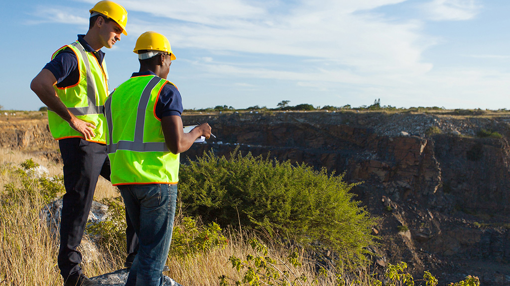 Two construction workers talking above a construction site 